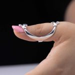 Anillo férula de plata ley 950 puesto en el dedo pulgar para soporte de hipermovilidad articular